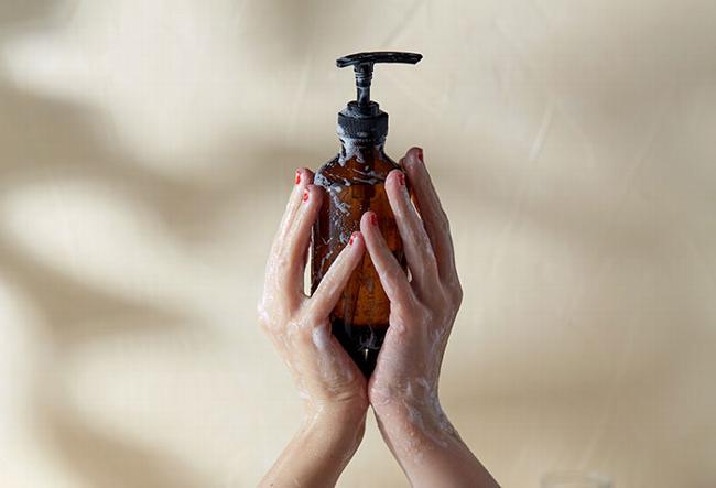 body wash bottle being held in soapy hands